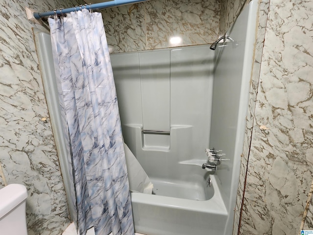 bathroom with shower / tub combo and toilet