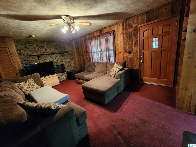 carpeted living room with ceiling fan, wood walls, and a textured ceiling