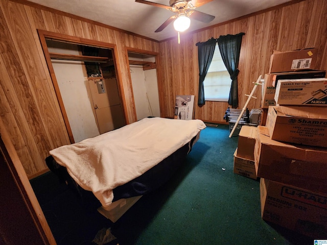 bedroom with ornamental molding, dark carpet, wooden walls, and multiple closets