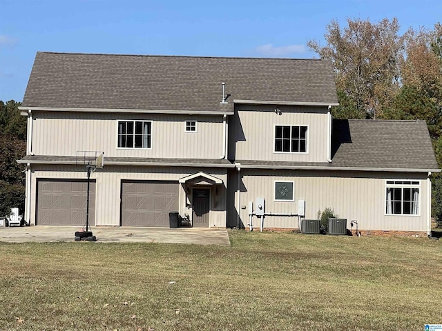 view of front of home featuring a garage, central AC unit, and a front yard