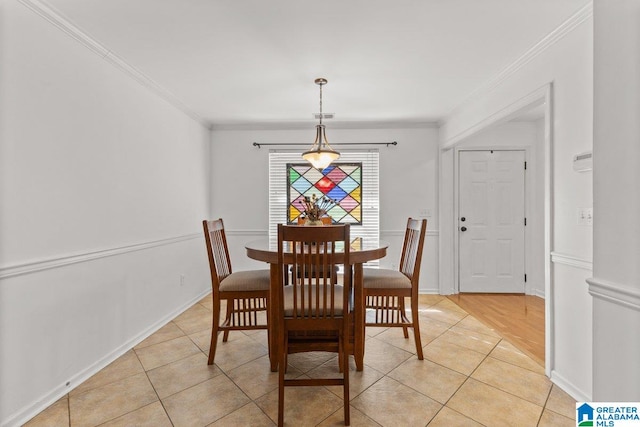 dining room featuring crown molding and light tile patterned flooring