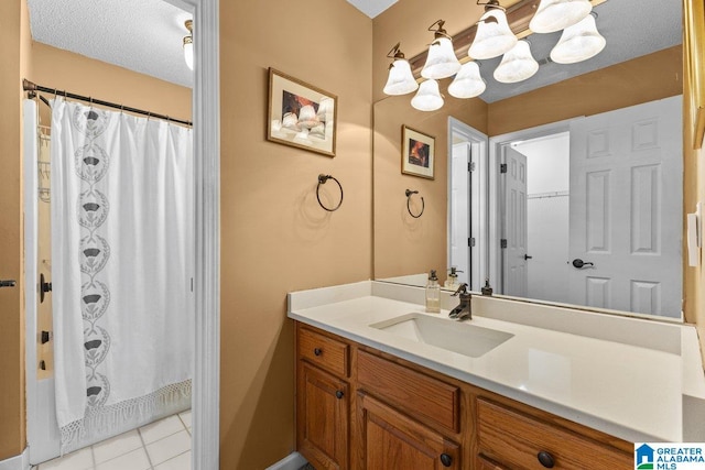 bathroom with walk in shower, tile patterned floors, vanity, and a textured ceiling