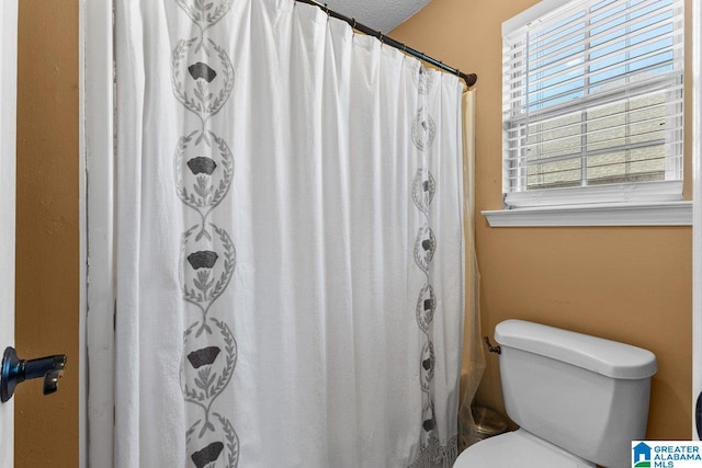 bathroom featuring a textured ceiling and toilet