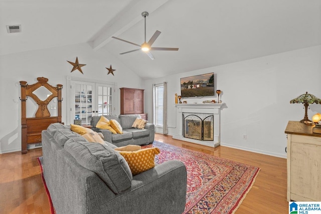 living room with hardwood / wood-style flooring, lofted ceiling with beams, french doors, and ceiling fan