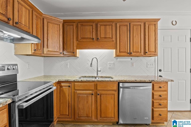 kitchen with tasteful backsplash, appliances with stainless steel finishes, sink, and light stone counters