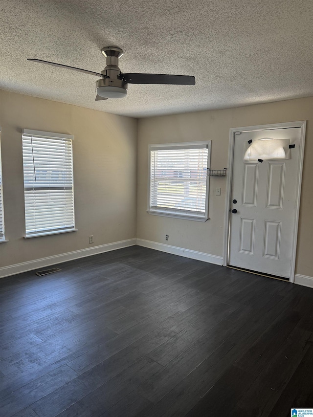 entryway with baseboards, ceiling fan, visible vents, and dark wood-type flooring