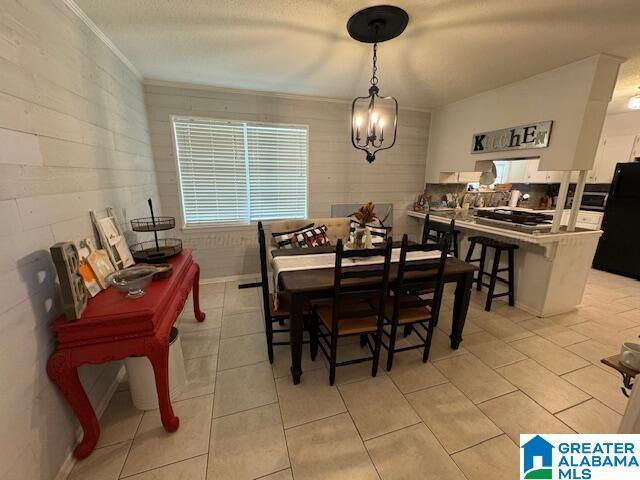 tiled dining area featuring a notable chandelier and a textured ceiling