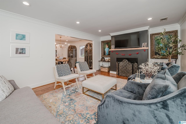 living room with hardwood / wood-style floors, ornamental molding, and a chandelier