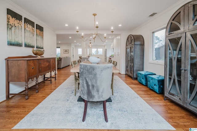 dining area with crown molding, wood-type flooring, and a wealth of natural light