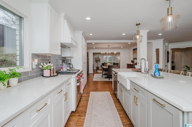 kitchen with white cabinetry, hanging light fixtures, sink, and appliances with stainless steel finishes