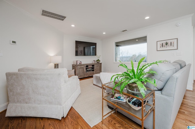 living room with ornamental molding and light wood-type flooring