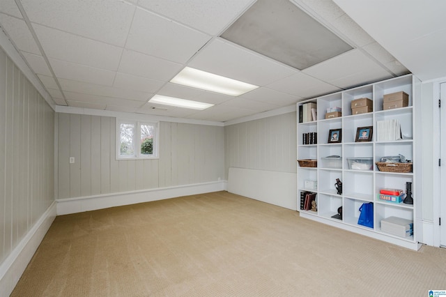 basement featuring light carpet and a drop ceiling