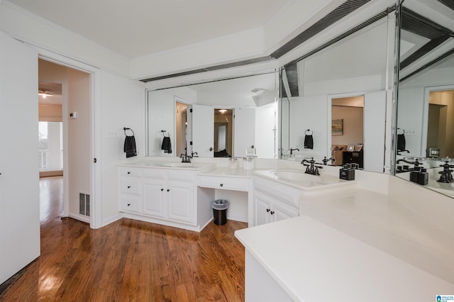 bathroom with vanity, hardwood / wood-style flooring, and crown molding