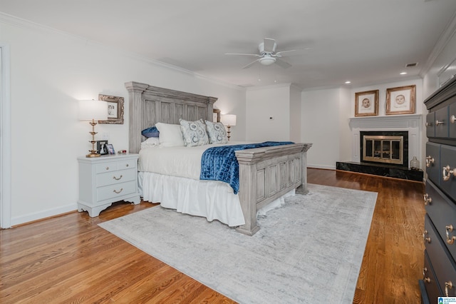 bedroom featuring ornamental molding, wood-type flooring, and ceiling fan