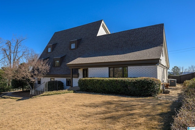 view of front of home featuring central AC and a front yard