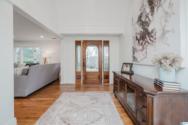 foyer entrance with light hardwood / wood-style floors and a high ceiling