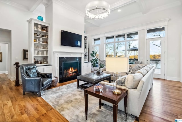 living room featuring hardwood / wood-style flooring, built in features, beam ceiling, coffered ceiling, and ornamental molding