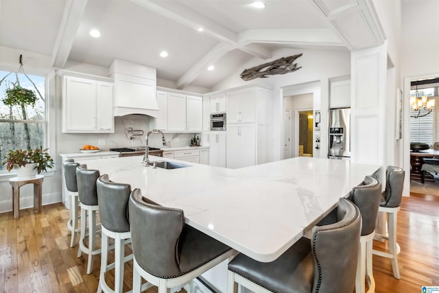 kitchen with a spacious island, decorative backsplash, white cabinets, and appliances with stainless steel finishes