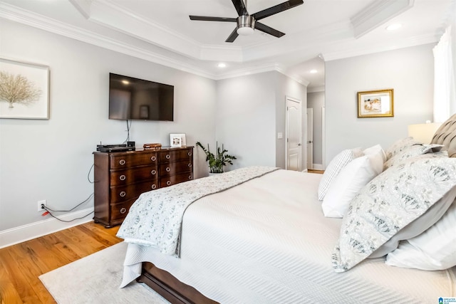 bedroom featuring ceiling fan, a tray ceiling, a closet, and light hardwood / wood-style flooring