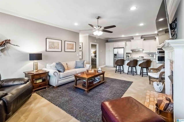 living room featuring sink, crown molding, and ceiling fan