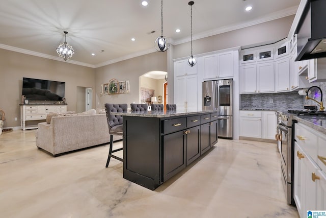 kitchen with stainless steel appliances, a center island, hanging light fixtures, and white cabinets