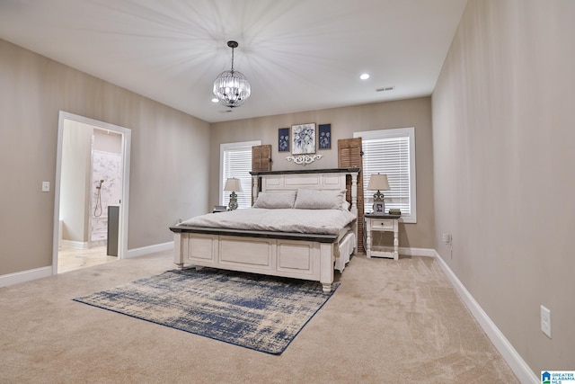 carpeted bedroom featuring connected bathroom and a chandelier