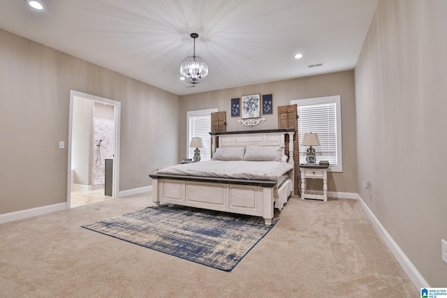 bedroom featuring a notable chandelier, light colored carpet, and ensuite bathroom