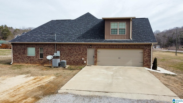 view of side of property with a garage and central AC