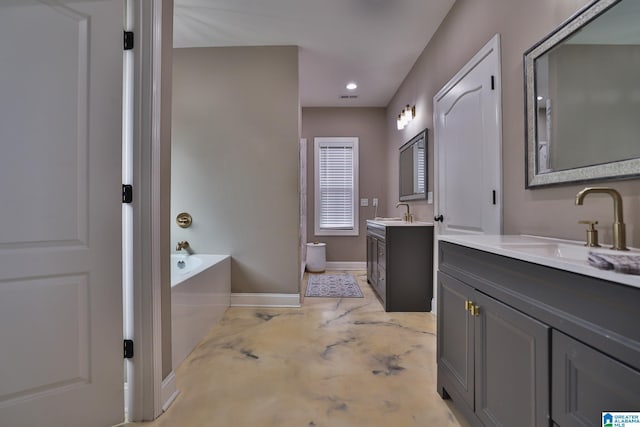 bathroom with vanity, concrete floors, and a tub