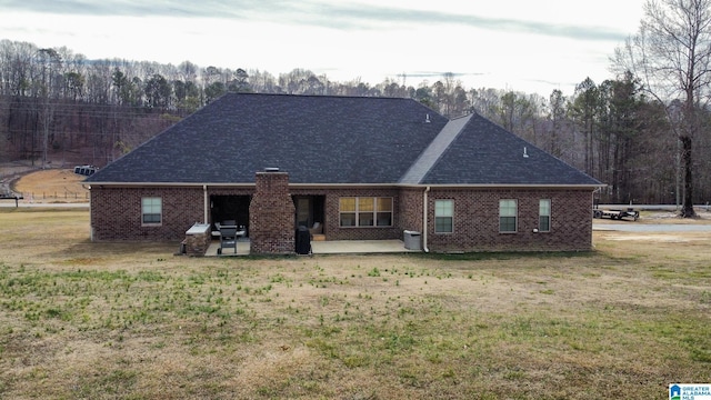 rear view of property featuring a yard and a patio