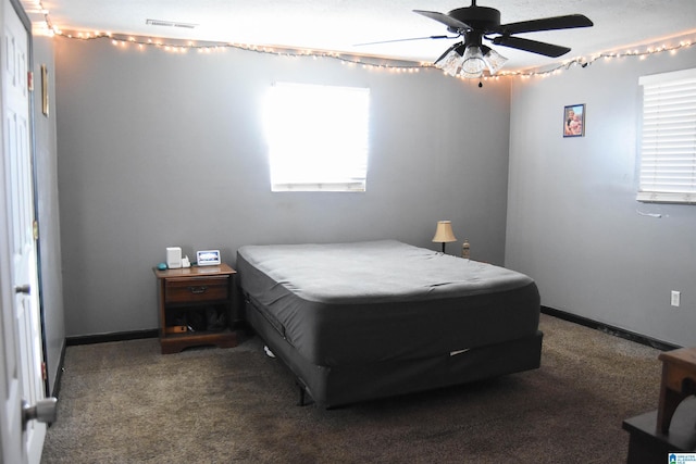 bedroom with ceiling fan and dark colored carpet