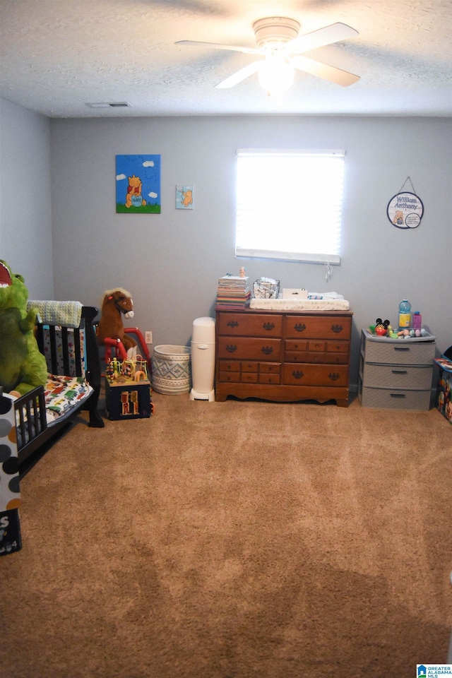 carpeted bedroom with a textured ceiling and ceiling fan