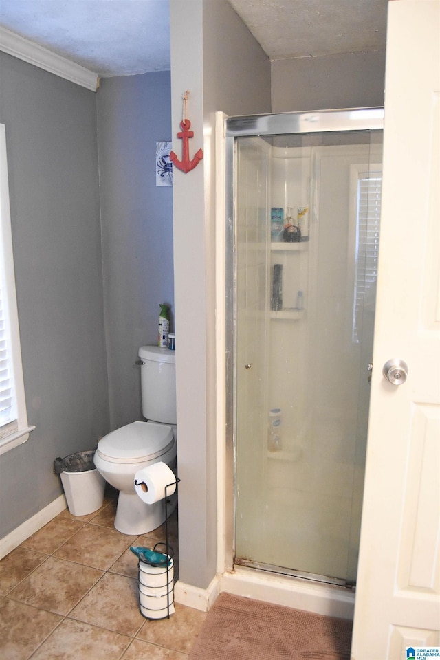 bathroom featuring ornamental molding, a shower with shower door, tile patterned floors, and toilet