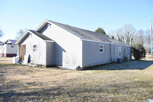 rear view of house with a lawn and central air condition unit