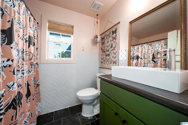 bathroom featuring walk in shower, vanity, toilet, and tile patterned flooring