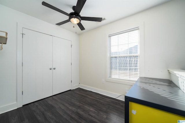 unfurnished bedroom featuring ceiling fan, dark hardwood / wood-style floors, and a closet