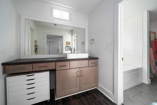 bathroom featuring vanity, hardwood / wood-style floors, and tiled shower / bath