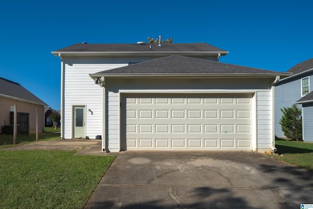 garage with central AC unit and a lawn