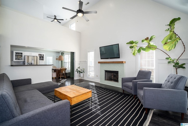 living room with a fireplace, plenty of natural light, high vaulted ceiling, and dark hardwood / wood-style floors