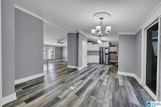 unfurnished dining area with crown molding, dark hardwood / wood-style flooring, and ceiling fan with notable chandelier