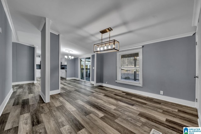 unfurnished living room with an inviting chandelier, hardwood / wood-style flooring, and ornamental molding