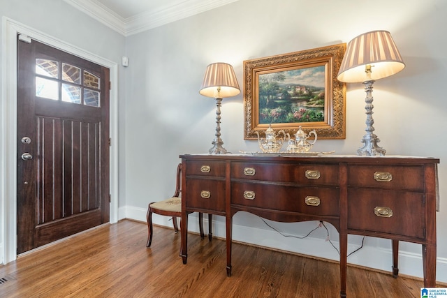 foyer with ornamental molding and wood-type flooring