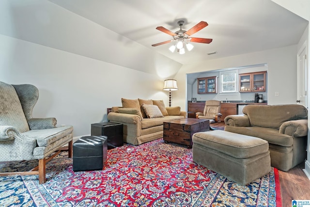 living room with lofted ceiling, light hardwood / wood-style floors, ceiling fan, and bar area