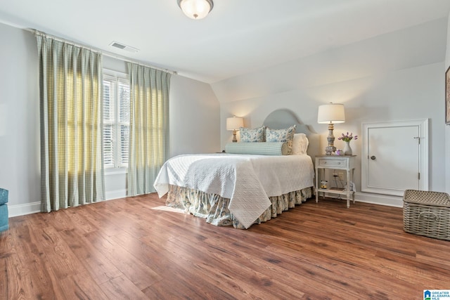 bedroom featuring hardwood / wood-style floors and vaulted ceiling