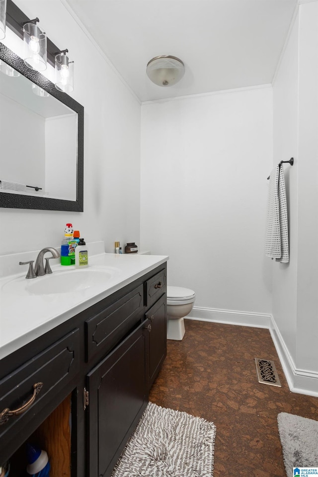 bathroom featuring crown molding, vanity, and toilet