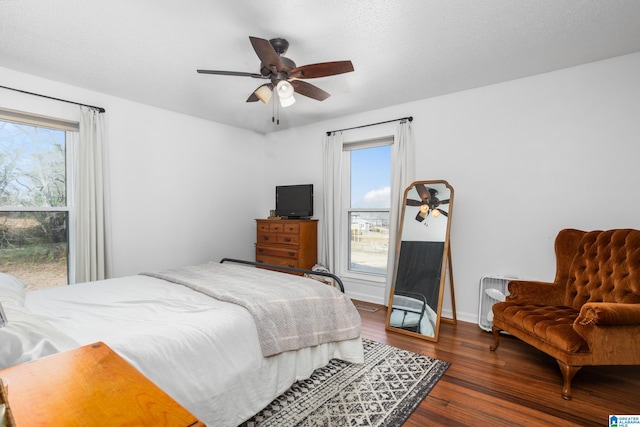 bedroom with ceiling fan, dark hardwood / wood-style floors, and a textured ceiling