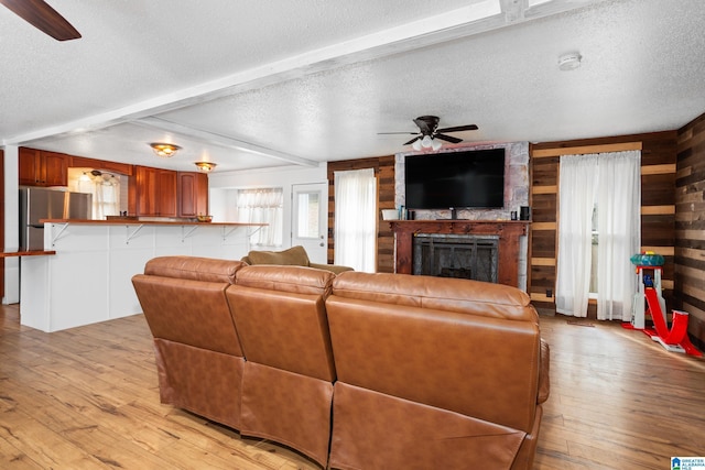 living room featuring a fireplace, light hardwood / wood-style floors, and a textured ceiling