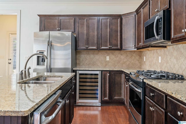 kitchen featuring appliances with stainless steel finishes, sink, backsplash, beverage cooler, and light stone counters