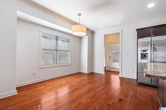 unfurnished dining area featuring crown molding and dark hardwood / wood-style floors