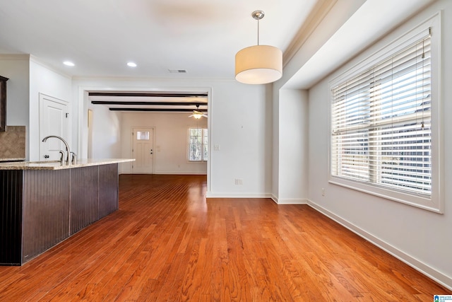 kitchen with pendant lighting, sink, hardwood / wood-style flooring, and dark brown cabinets